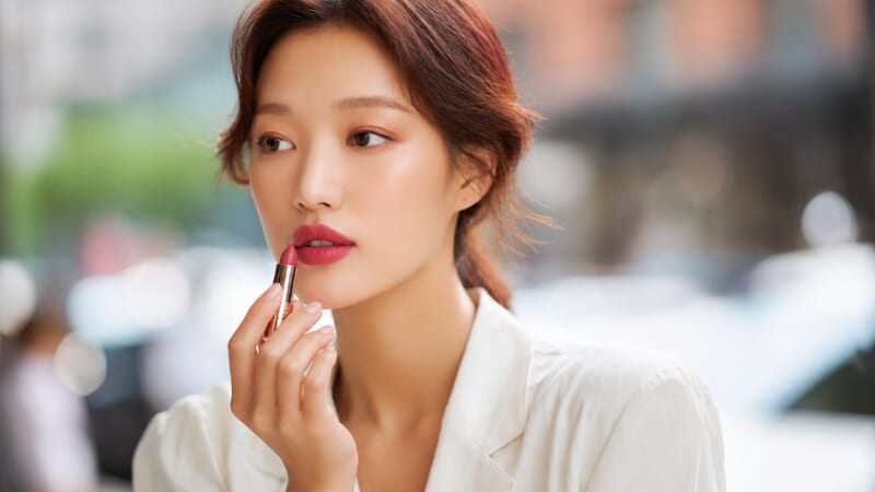 出先でリップを塗る女性